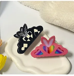 Dettaglio di fermacapelli a scacchi e cuore rosa con design a orecchie di coniglio