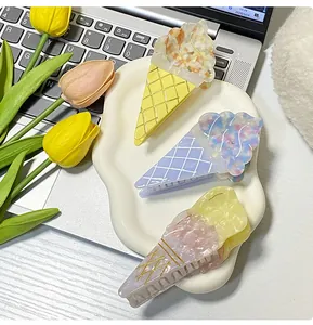 Dettaglio di tre mollette per capelli a forma di gelato pastello con trama marmorizzata