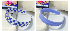 Detail view of wide checkerboard and purple hairbands on a clean lifestyle background