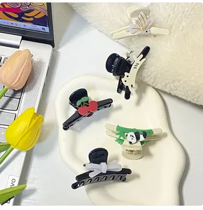 Detailed set of cute panda and cat hair clips on a ceramic tray with floral decor