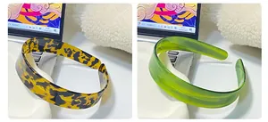 Detail view of wide tortoiseshell and translucent green acetate headbands in home setting