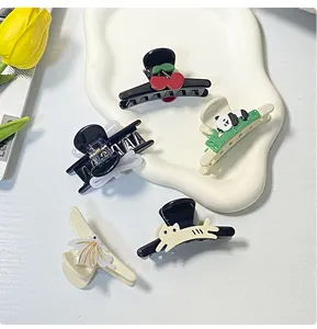 Detail showing five assorted acetate hair clips including cherry and panda designs