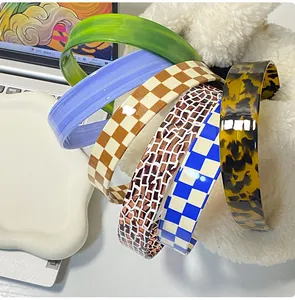 Detail view of colorful checkered and solid headbands in glossy resin and plastic finish