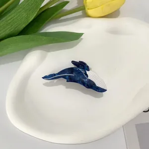 Close-up of a blue orca whale hair claw clip made of marble texture acetate material