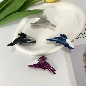 Orca whale acetate hair claws in four colors displayed with elegant tulips