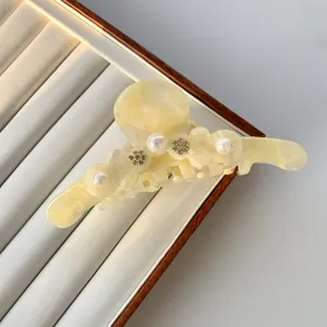 Detail der Haarklammer aus Acetat in Cremeweiß mit Marmorierung, Perlen und Strasssteinen