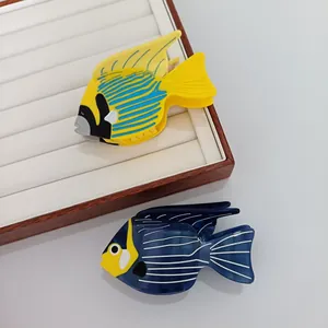 Pinces à cheveux en acétate en forme de poissons tropicaux sur un plateau à bijoux