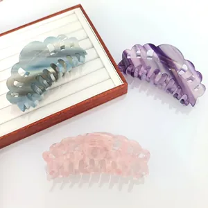 Detailed view of three 14cm acetic acid hair claws with marble textures in blue, purple, and pink