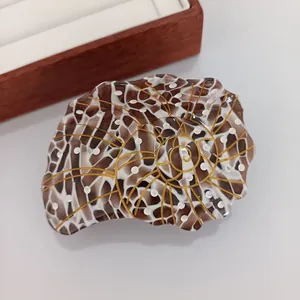 Détail de la pince à cheveux nautile avec motif écaille de tortue et finitions dorées