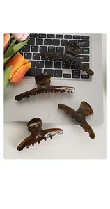 Detail of tortoiseshell acetate hair claws and side clips on laptop keyboard