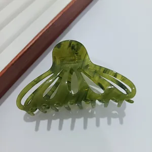 Détail d'une pince à cheveux en acétate vert écaillé avec gravure France Handmade artisanale