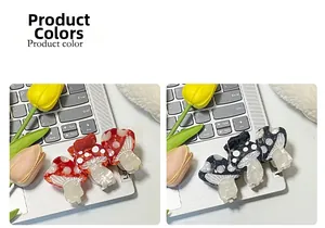 Macro detail of red and black acetate mushroom hair claws with white polka dots