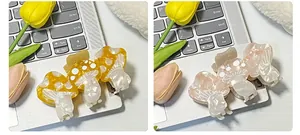 Detail of mushroom-shaped acetate hair clips with pearl texture and white polka dots