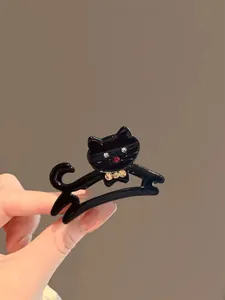 Dettaglio di una molletta per capelli a gatto nera in acetato con strass scintillanti