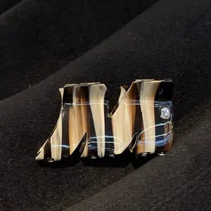 Close-up of tortoise shell hair claw with crystal M design and gold handmade text