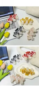 Close-up of mushroom-shaped acetate hair claws with marble texture and white polka dots