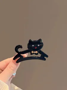 Dettaglio di un fermaglio per capelli a gatto nero con strass lucidi e un fiocco