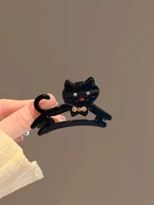 Dettaglio ravvicinato di una molletta per capelli a forma di gatto nero con strass colorati