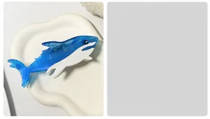 Detailed close-up of a blue and white shark-shaped hair claw clip made of acetate material
