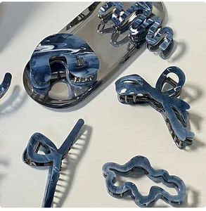 Dettagli di pinze per capelli in acetato marmorizzato blu con forme geometriche
