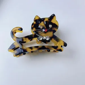Dettaglio molletta per capelli a gatto in acetato con occhi in strass e fiocco