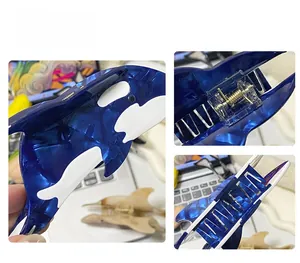 Detailansicht der Orca-Haarklammer aus Acetat mit blau-weißer Marmorierung und Metallfeder