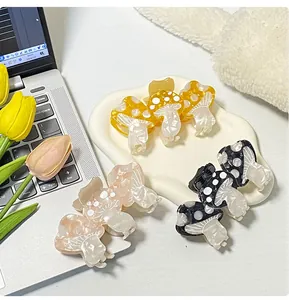 Detailed view of mushroom hair claws in yellow, pink and black on a white tray