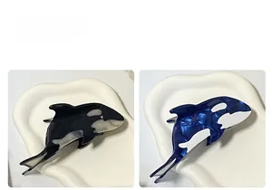 Nahaufnahme der Orca-Haarklammern aus Acetat in Schwarz und Blau mit Marmorierung