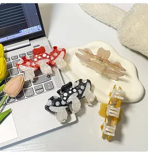 Close-up of cute mushroom-shaped acetate hair claws and colorful clips on a tray