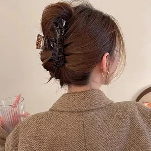 Elegant tortoiseshell acetate hair claw clip for women styled in a hair bun