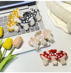 Cute mushroom hair clips in acetate finish with white polka dots on a laptop setup