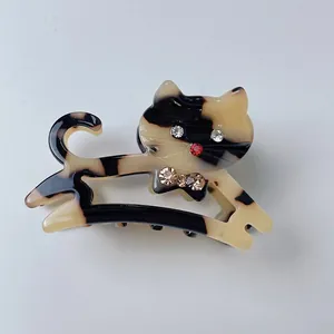 Dettaglio molletta per capelli a gatto in acetato con strass e motivo tartarugato