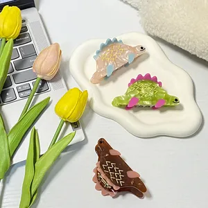 Tre fermagli per capelli a forma di dinosauro in acetato con texture effetto marmo