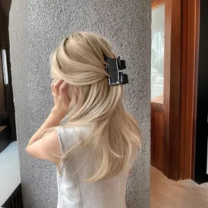 French style black acetate hair claw clip with M-letter and marble texture on blonde hair