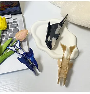 Detailansicht der Haarspangen im Orca-Design aus Acetat auf einem Keramiktablett