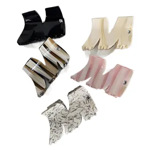 Elegant M-shaped acetate hair claws with marble patterns and sparkling rhinestone letters