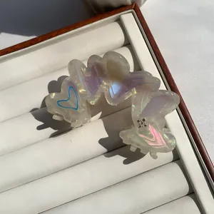 Elegant heart-shaped pearlescent acetate hair claw clip with crystal diamond accents