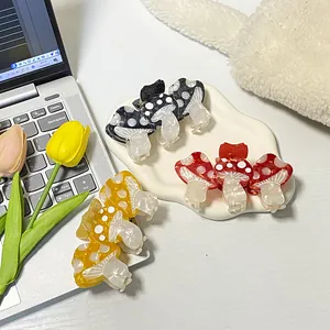 Three cute acetate mushroom hair claws in red, black, and yellow with white polka dots