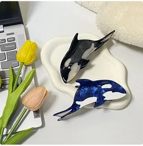 Detail von Haarklammern in Orca-Form aus Acetat in Schwarz und marmoriertem Blau