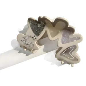 Elegant heart-shaped hair claw with glitter and marble texture on white stand