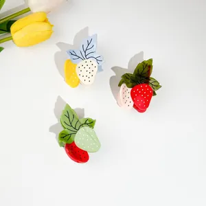 Trois pinces à cheveux fraises en acétate colorées avec pois sur fond blanc épuré