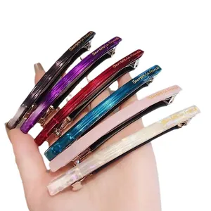 Lot de six barrettes en acétate coloré avec lettrage doré sur un fond blanc propre