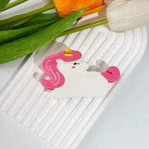 Détail d'une pince à cheveux licorne mignonne sur un plateau à vagues blanc