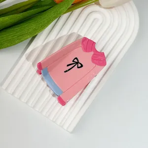 Detail of pink acetate hair claw clip in a creative shirt shape with blue accents