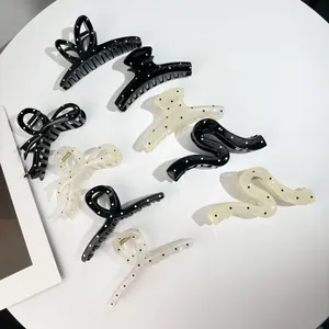 Vue détaillée de pinces à cheveux à pois noirs et blancs aux formes de nœuds variées