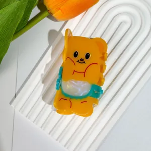 Dettaglio della molletta per capelli a forma di orso giallo in acetato con finitura lucida
