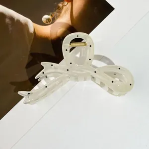 Détail d'une pince à cheveux à pois noirs sur fond de magazine de mode élégant et moderne