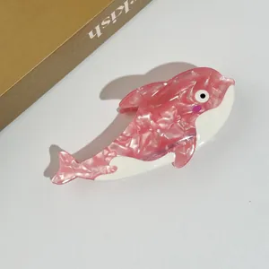 Detail of dolphin-shaped hair claw made of pink marble pattern acetate with white inlay