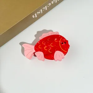 Close-up of a creative red whale hair claw made of polished acetate with pink accents