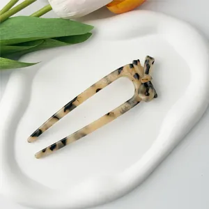 Detail of tortoise shell U-shaped hair stick with a bow knot design on ceramic tray